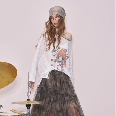 Woman wearing a graphic t-shirt and black tulle skirt in a room with musical instruments.